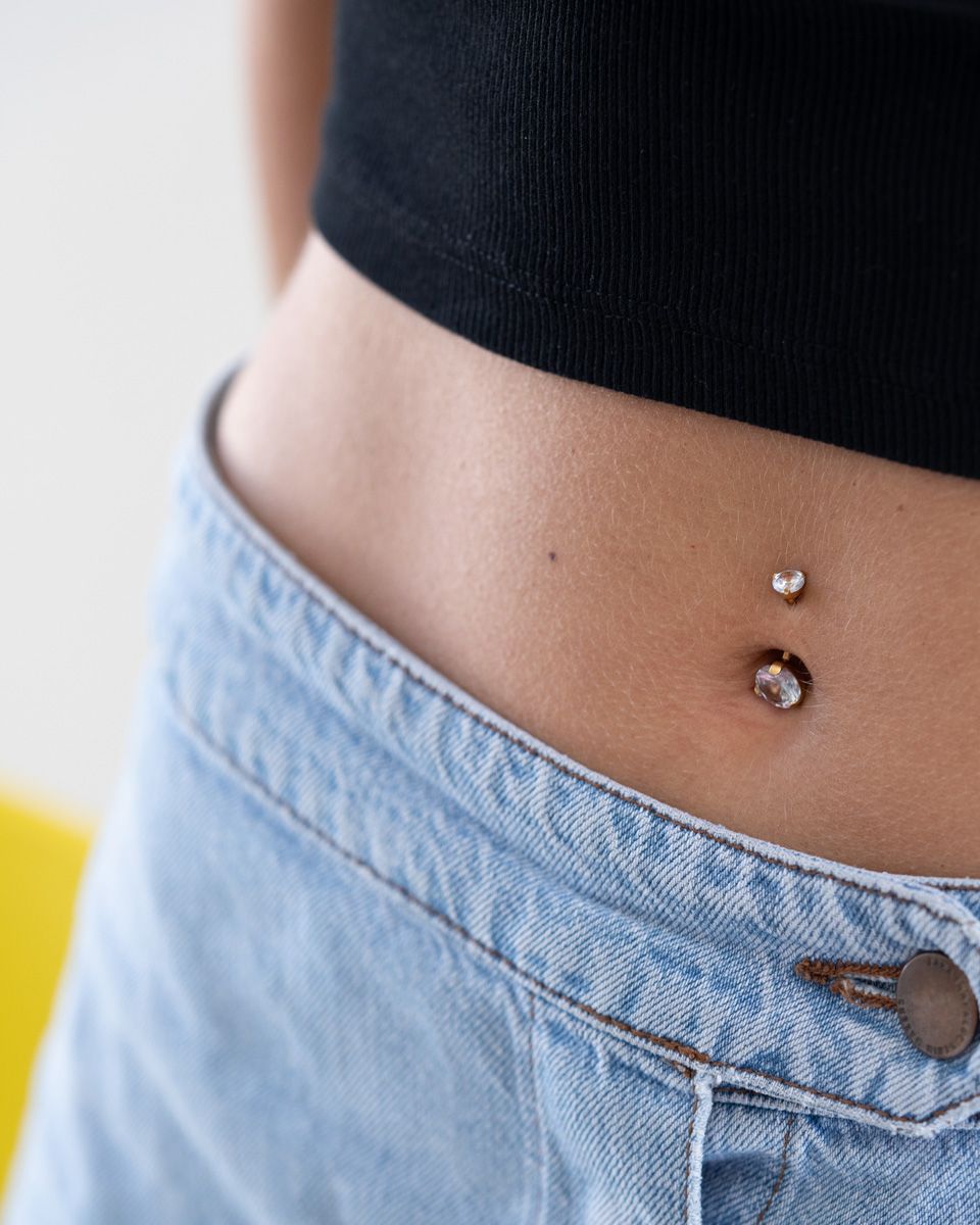 Bauchnabelpiercing mit großen Steinen in der oberen und unteren Kugel