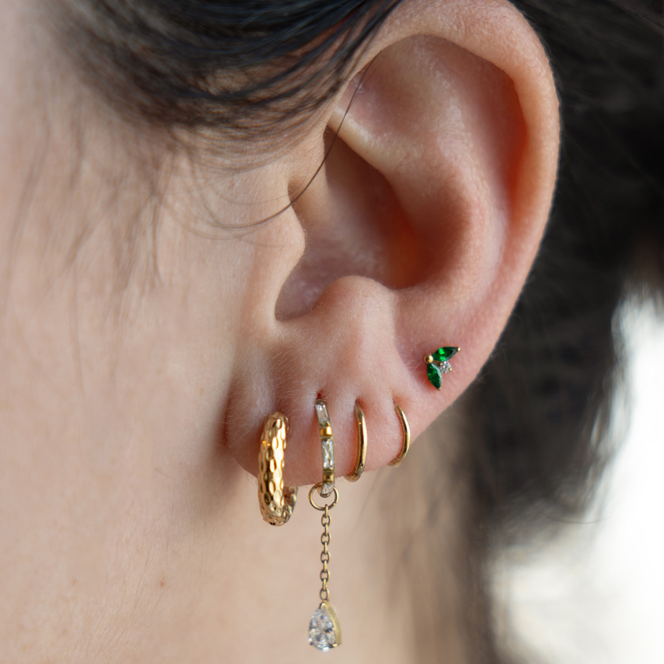 Titan-Labret mit zwei smaragdgrünen Schmucksteinen